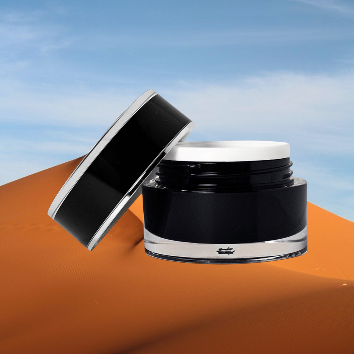 Maison Sultanat Kohl's Gaze eye contour cream in an elegant black jar against desert dunes and blue sky